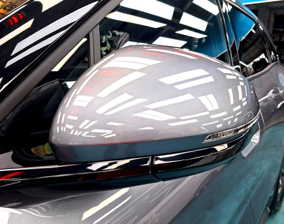 Grey wing mirror on the Atto 2 with reflections in the paint.