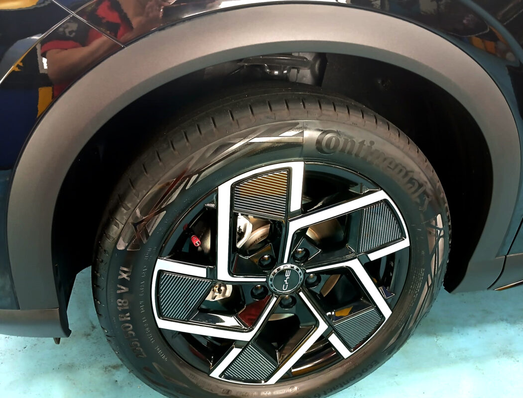 The coated bonnet of the BYD ATTO 3 under workshop lighting.