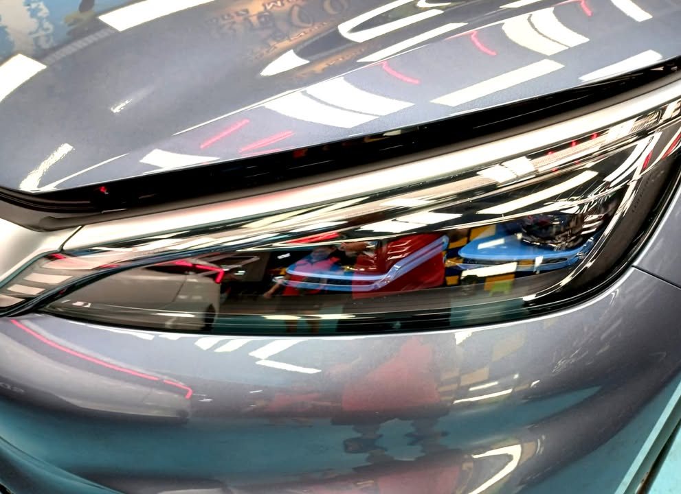 Close-up of the Atto 3 headlamp beside the grey-blue front wing.