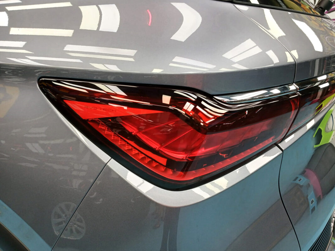The coated bonnet of the BYD ATTO 3 under workshop lighting.