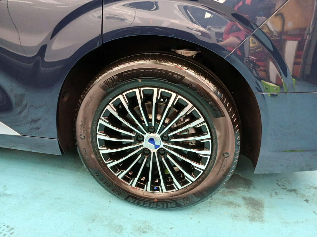 The coated bonnet of the BYD DENZA D9 under workshop lighting.