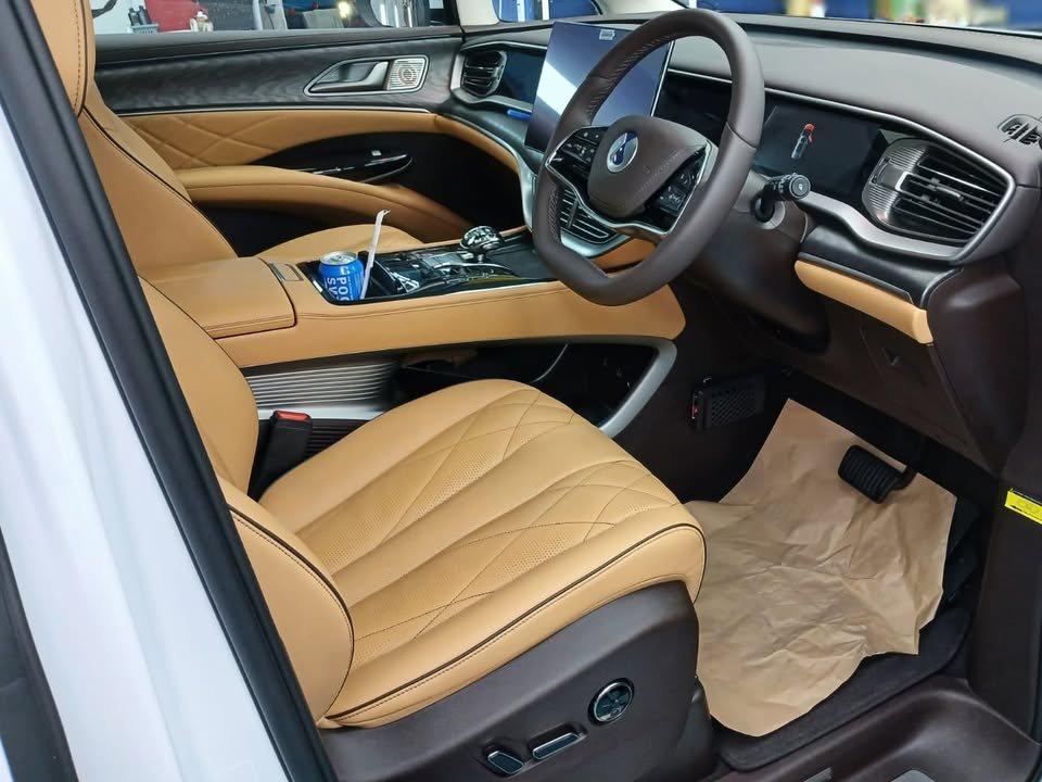 Denza D9 front cabin with tan leather seats and digital dashboard.