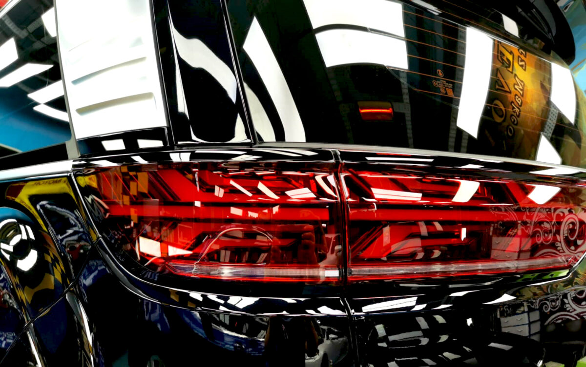 The coated bonnet of the BYD Denza under workshop lighting.