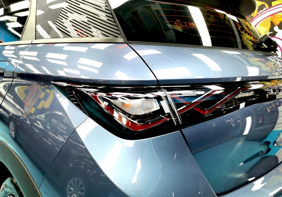 The coated bonnet of the BYD Dolphin under workshop lighting.