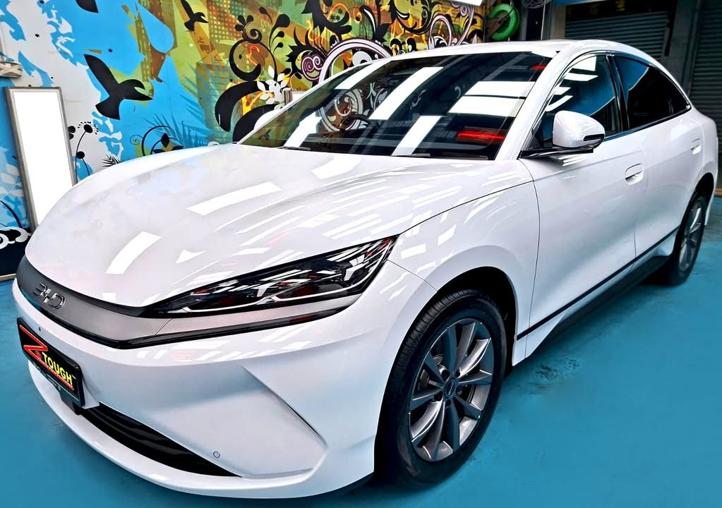 White BYD Seal 6 from the front three-quarter on the workshop's blue floor.