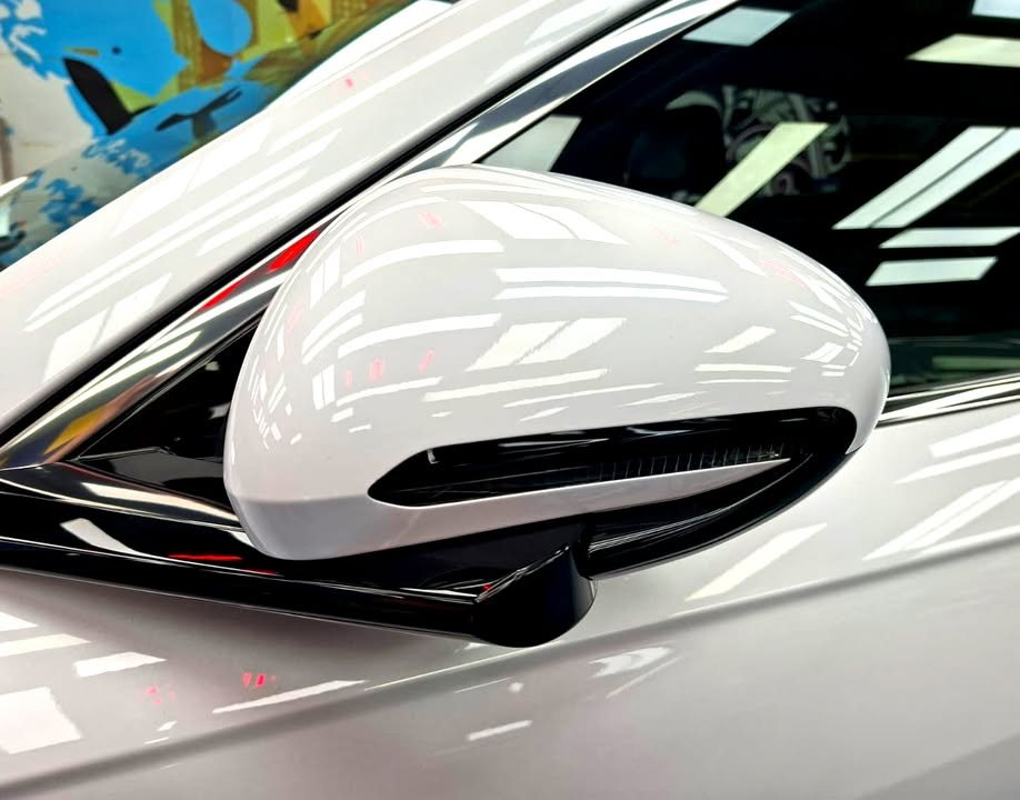 White side mirror cap reflecting the workshop lights.