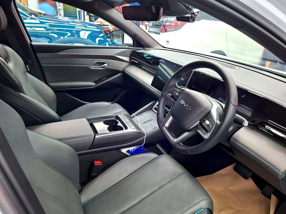 Interior with grey seats, steering wheel and wide dashboard screen.