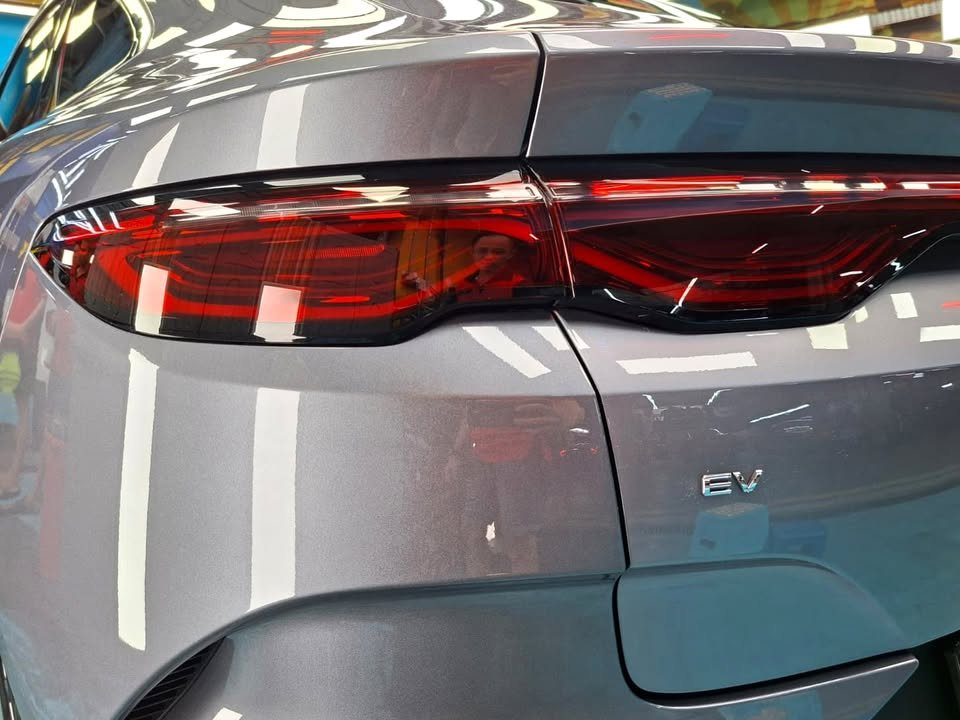 Close-up of the red tail lamp and EV badge on the grey boot lid.