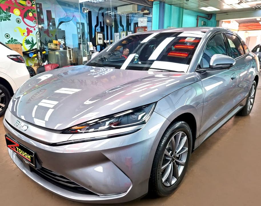 Grey BYD Seal 6 from the front three-quarter, its bonnet reflecting the workshop lights after the ZeTough Ceramic coating.