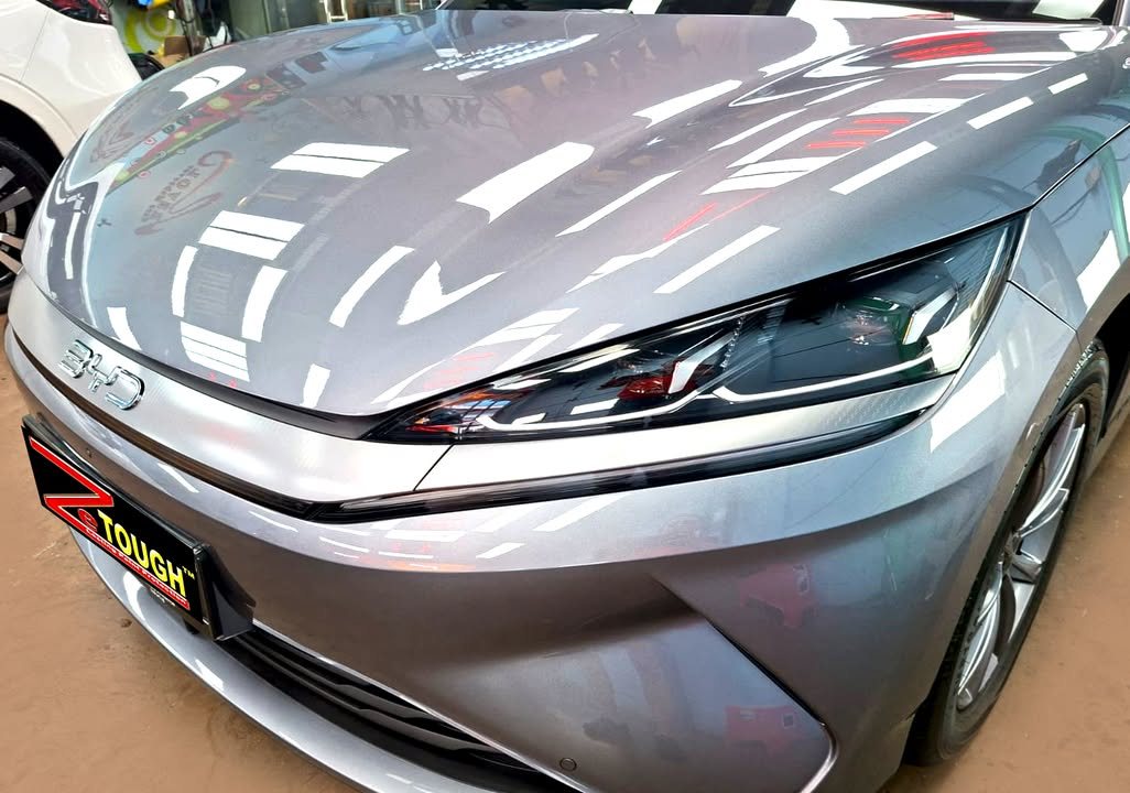 Front of the grey BYD Seal 6 showing the BYD lettering and headlamp.