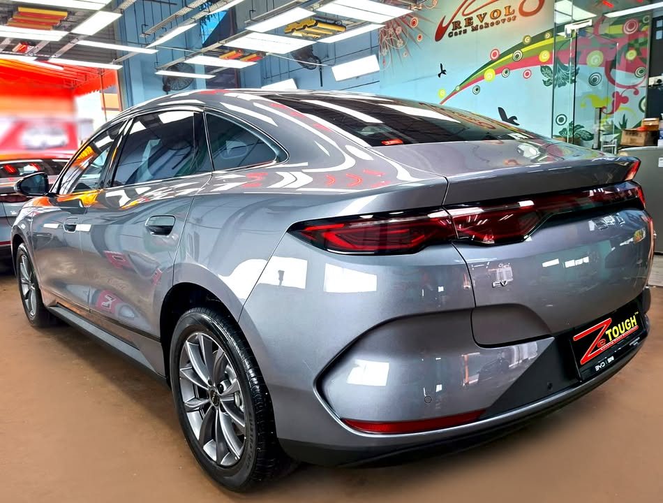 Rear three-quarter view of the grey BYD Seal 6 in the workshop.