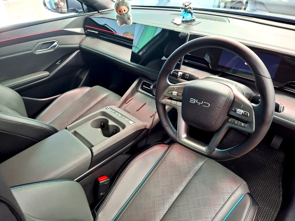 Grey front seats, steering wheel and dashboard inside the BYD Seal 6.
