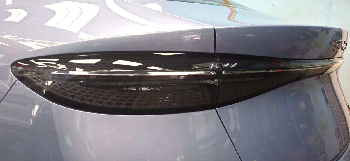The coated bonnet of the BYD Seal Dynamic under workshop lighting.