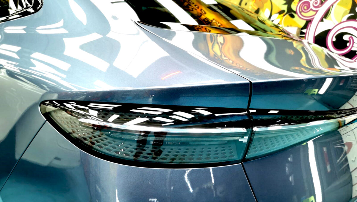 The coated bonnet of the BYD Seal under workshop lighting.