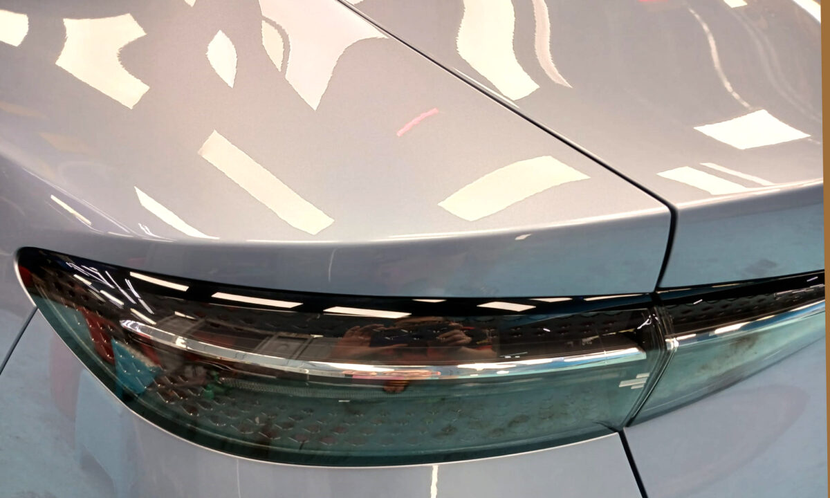The coated bonnet of the BYD Seal under workshop lighting.