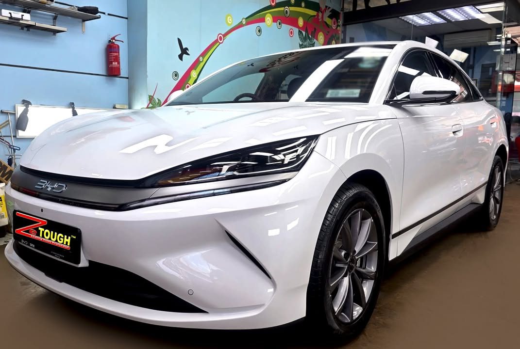 White BYD Sealion 6, front three-quarter view in the workshop, with a ZeTough plate on the front bumper.