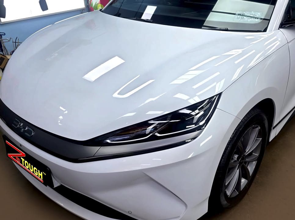Front of the white Sealion 6 showing the bonnet reflections, headlight and BYD lettering.
