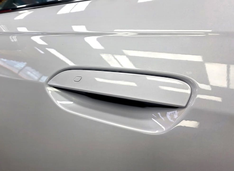 Flush door handle on the white door panel.