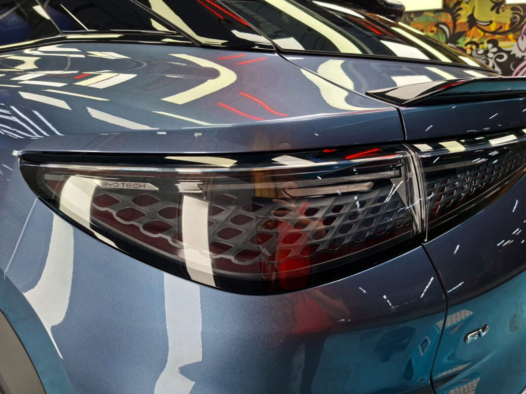 The coated bonnet of the BYD Sealion 7 under workshop lighting.