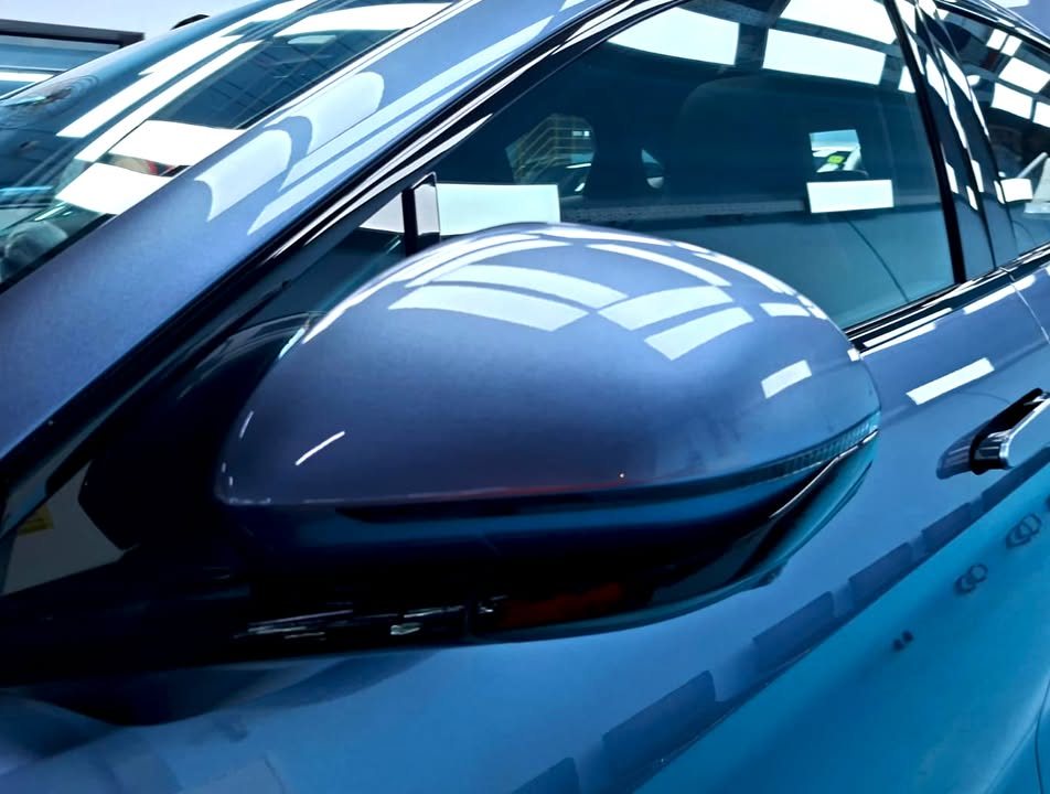 Blue grey side mirror cap with a glossy reflection.