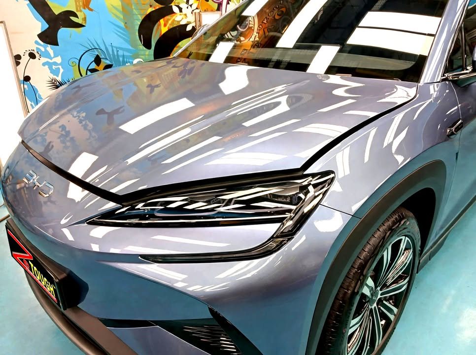 Close-up of the blue-grey bonnet, headlamp and front wing.