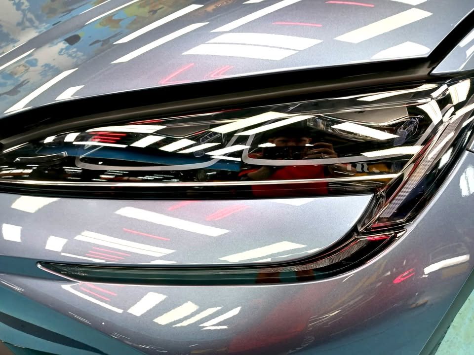 Close-up of the headlamp with light reflections on the paint around it.