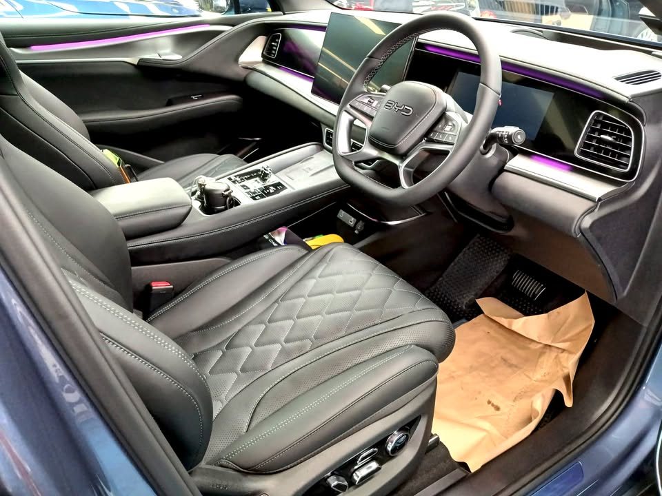 Interior view of the quilted black seats, steering wheel and dashboard.