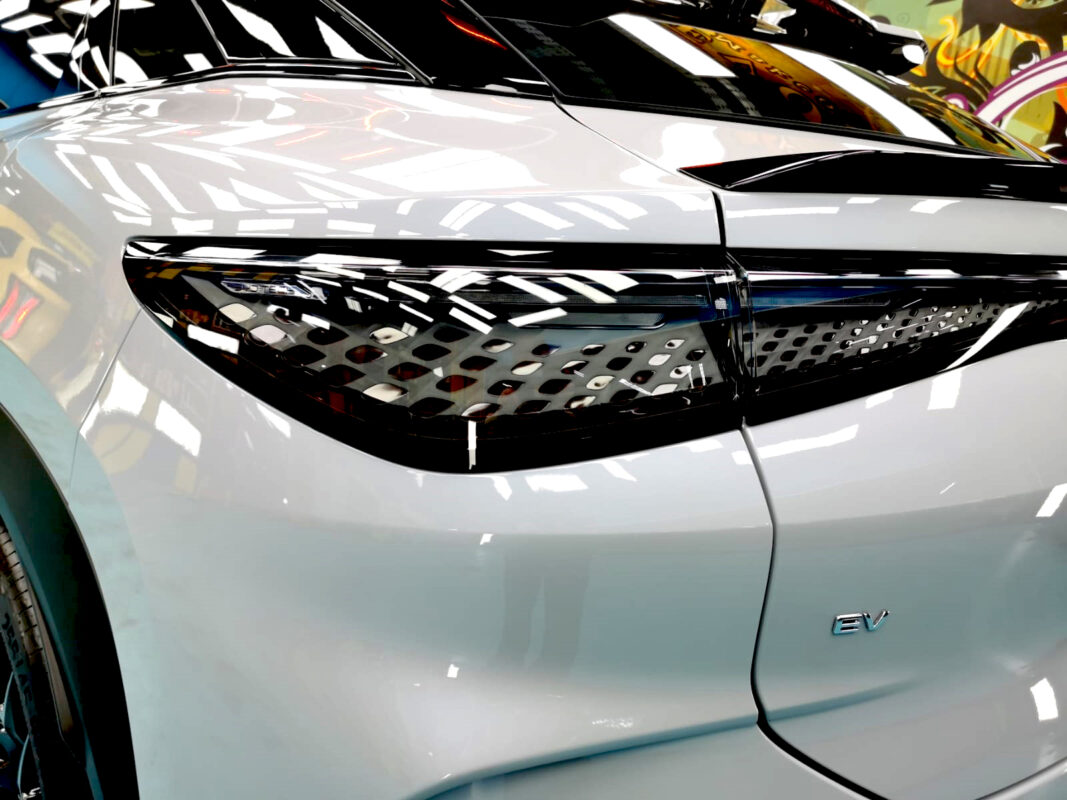 The coated bonnet of the BYD Sealion under workshop lighting.