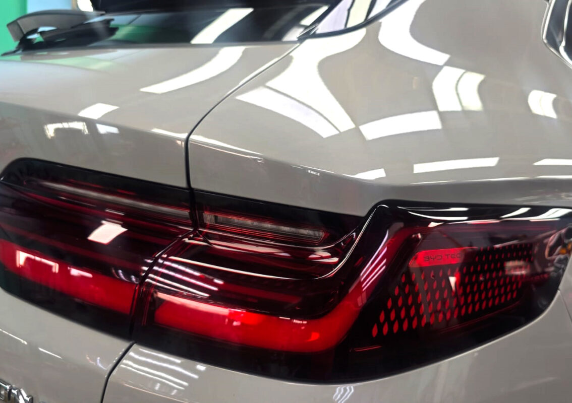 The coated bonnet of the BYD Sealion under workshop lighting.