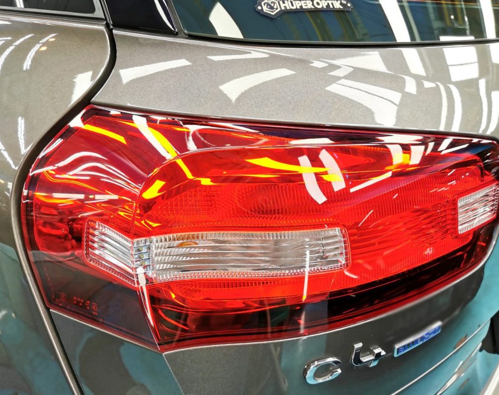 The coated bonnet of the Citroen C4 Picasso under workshop lighting.