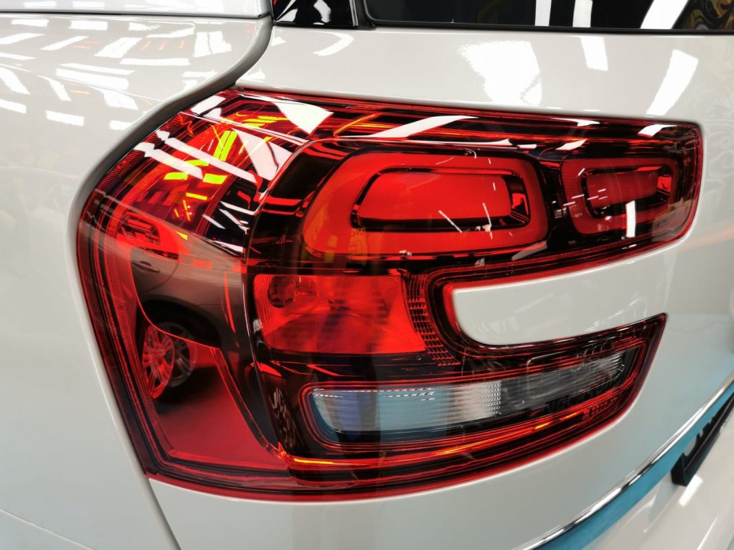 The coated bonnet of the Citroen Grand C4 Space Tourer under workshop lighting.