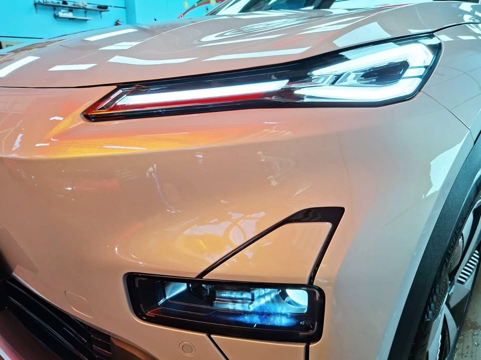 Close-up of the Deepal S05 headlight and lower light unit with reflections in the light grey paint.