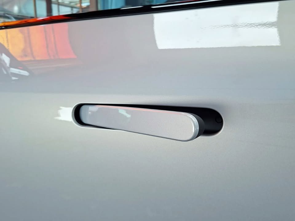 Flush door handle on the light grey door panel.