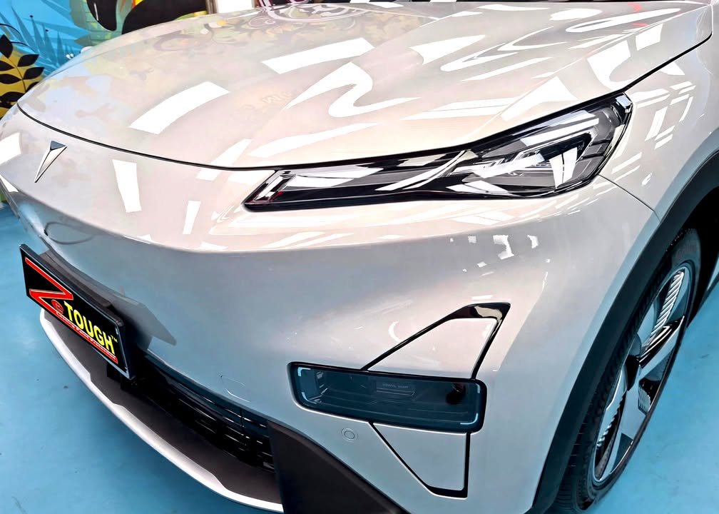 Front bumper and headlight of the light grey Deepal S05 with workshop reflections.