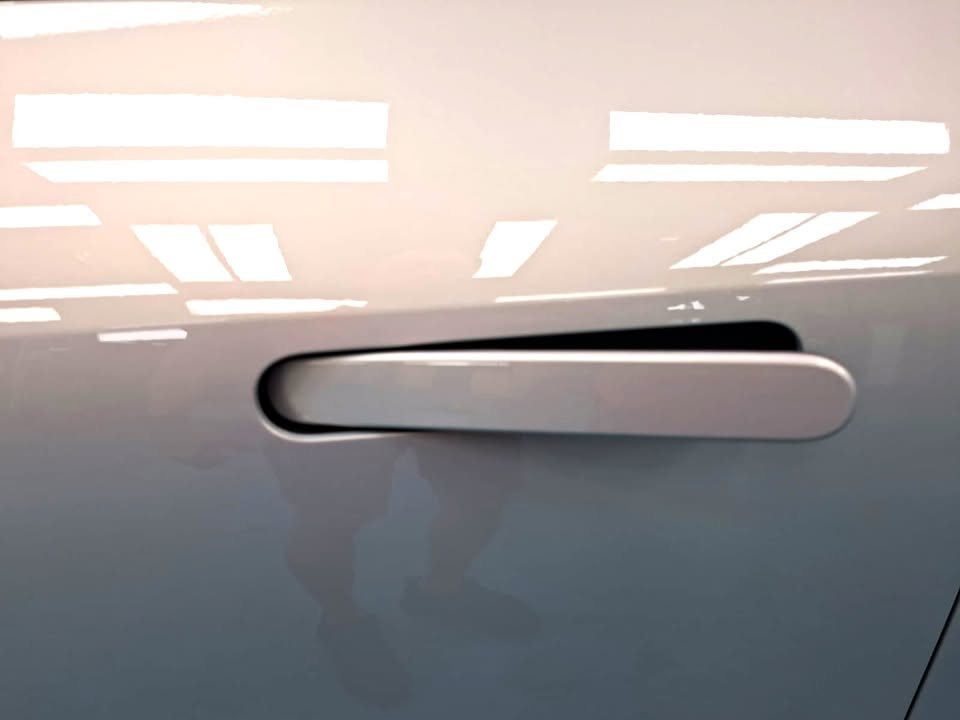 Flush door handle on the light grey door panel.