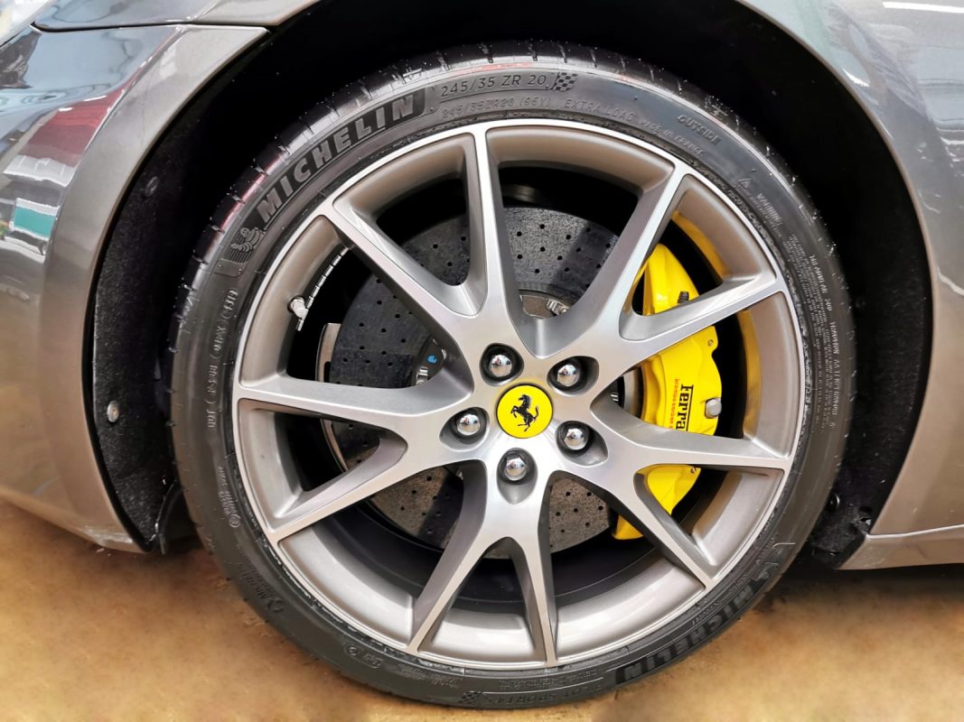 The coated bonnet of the Ferrari California under workshop lighting.