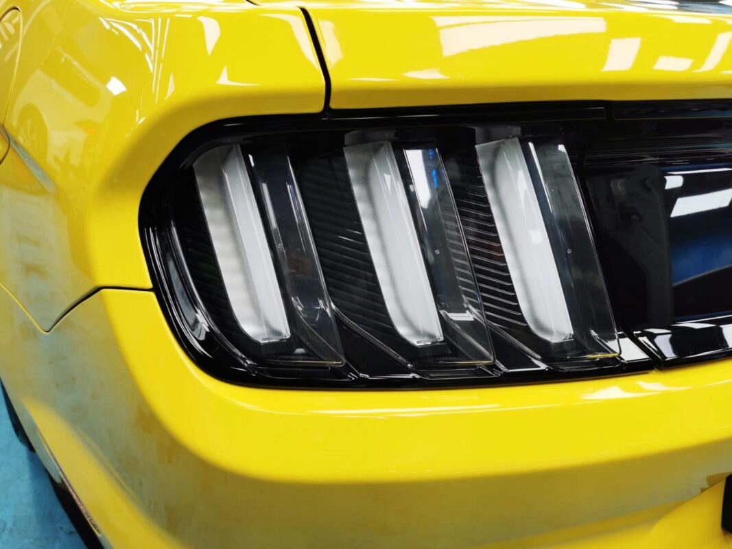 The coated bonnet of the Ford Mustang under workshop lighting.