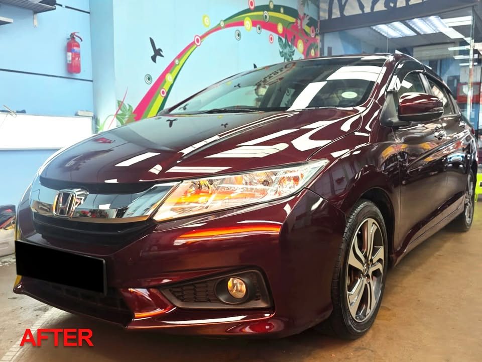 Maroon Honda City from the front three-quarter in the workshop after its full respray.