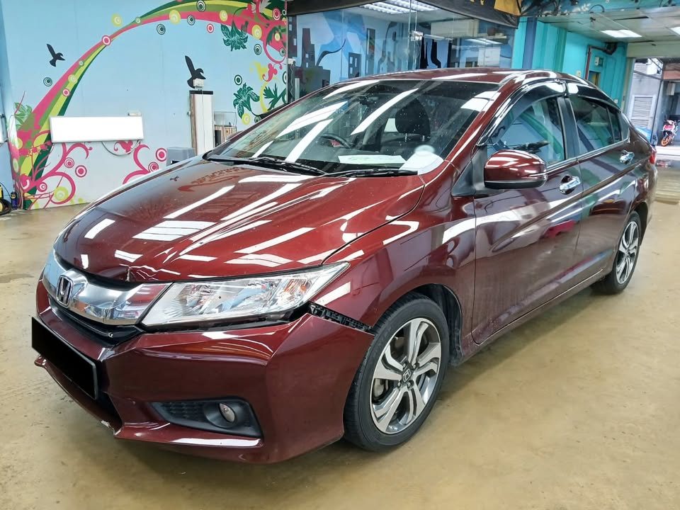 Maroon Honda City from the front three-quarter before the respray, with dull paintwork.