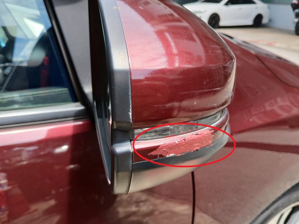 Door mirror of the Honda City with a scuff on the lower edge circled in red.