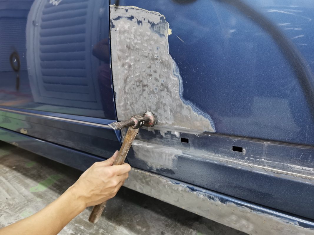 The Honda Civic's surface being checked for scratches and dents.