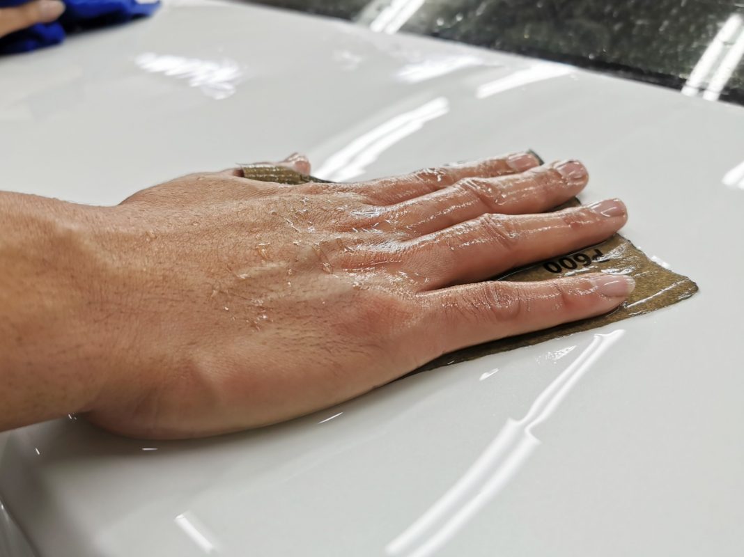 Wet-sanding the Civic's panels to smooth the surface.