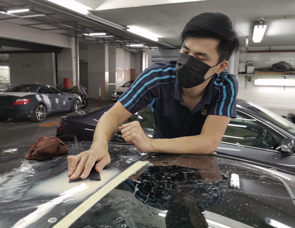 Wet-sanding the Civic's panels to smooth the existing paintwork.
