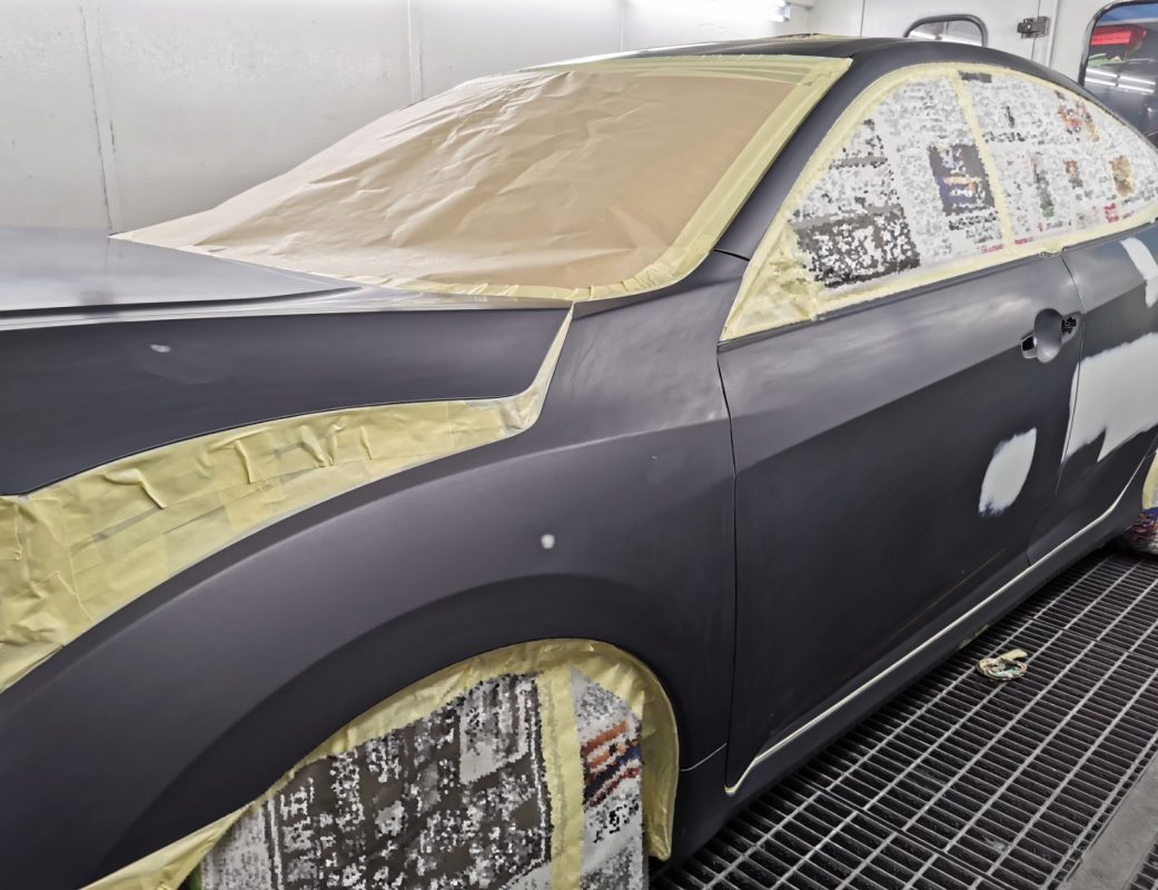 Non-painted surfaces being masked off on the Civic before spraying.