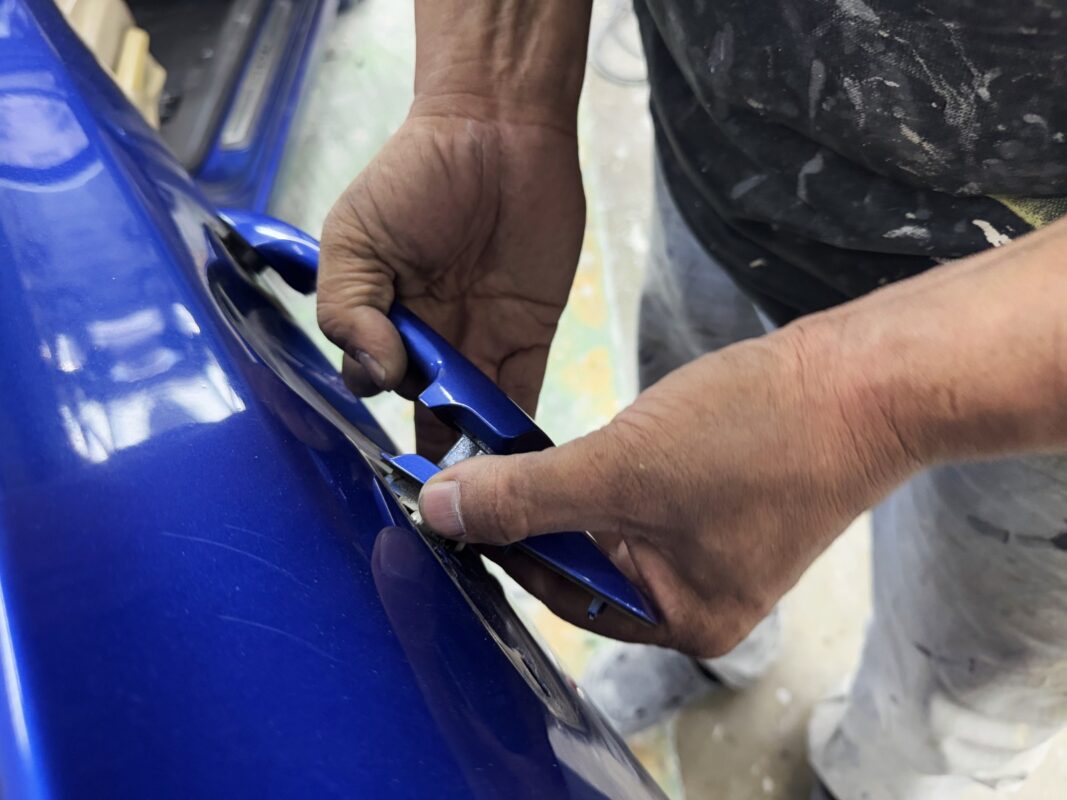 Car parts being dismantled from the Honda Civic in preparation for spraying.