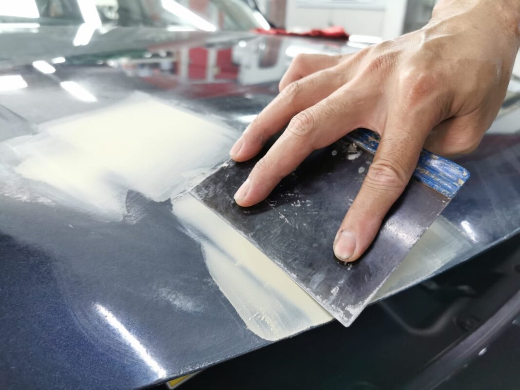 Dent and scratch repair work on a panel of the Honda Civic.