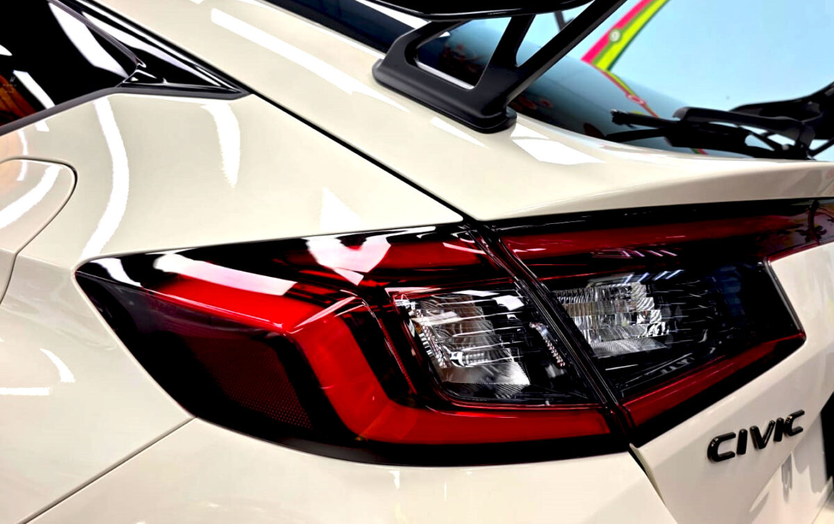 The coated bonnet of the Honda Civic under workshop lighting.