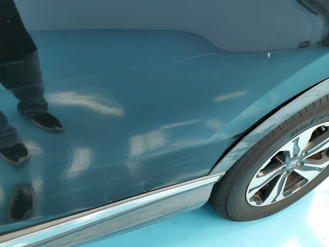 Damaged paintwork on a panel of the Honda CR-V, showing stone chips and scratches.