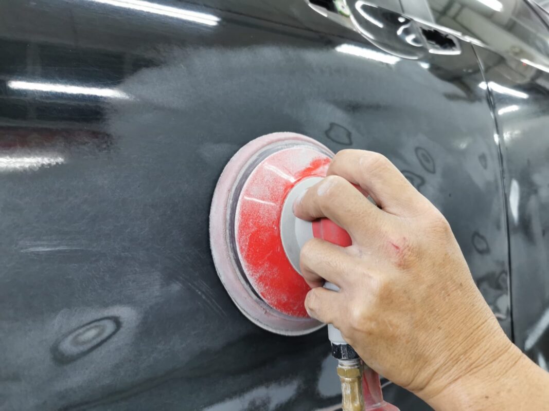 Bodywork on the Honda CR-V being patched and sanded smooth before painting.