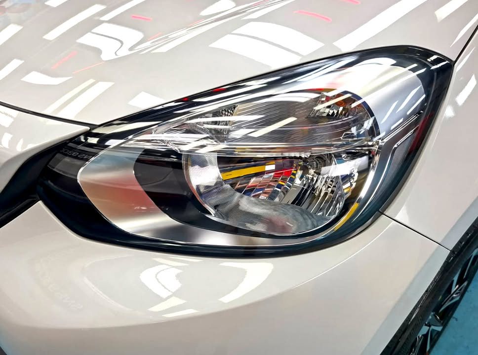 Close-up of the Honda Fit headlight and white front wing.